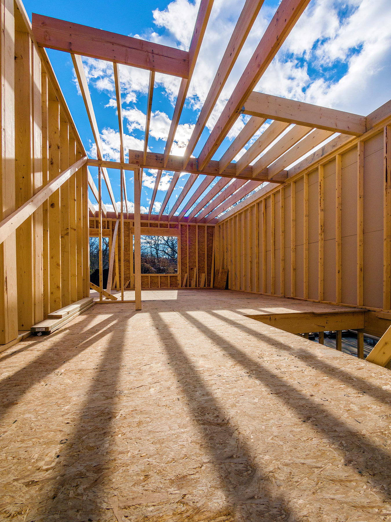 Wood framing for a custom home under construction showing structural walls, floor system, and roof framing before mechanical installation.
